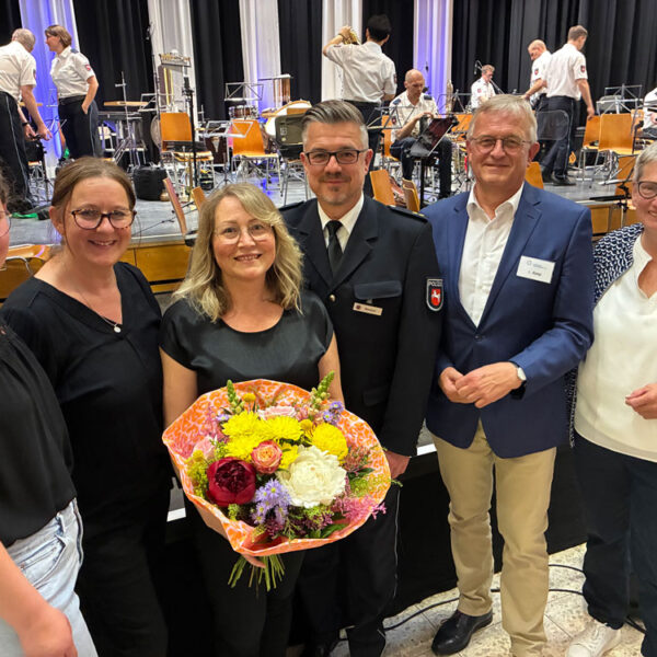 Die Initiatoren des Konzertes stehen nebeneinander, mit blumenstrauß